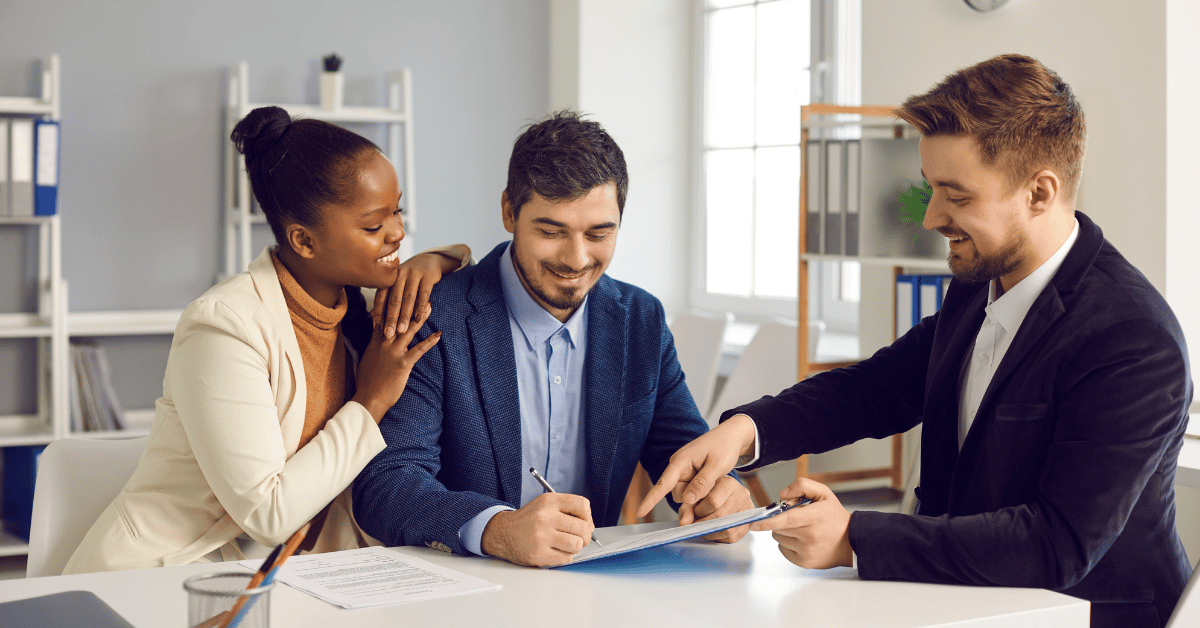 Couple signant des documents de prêt immobilier chez un notaire