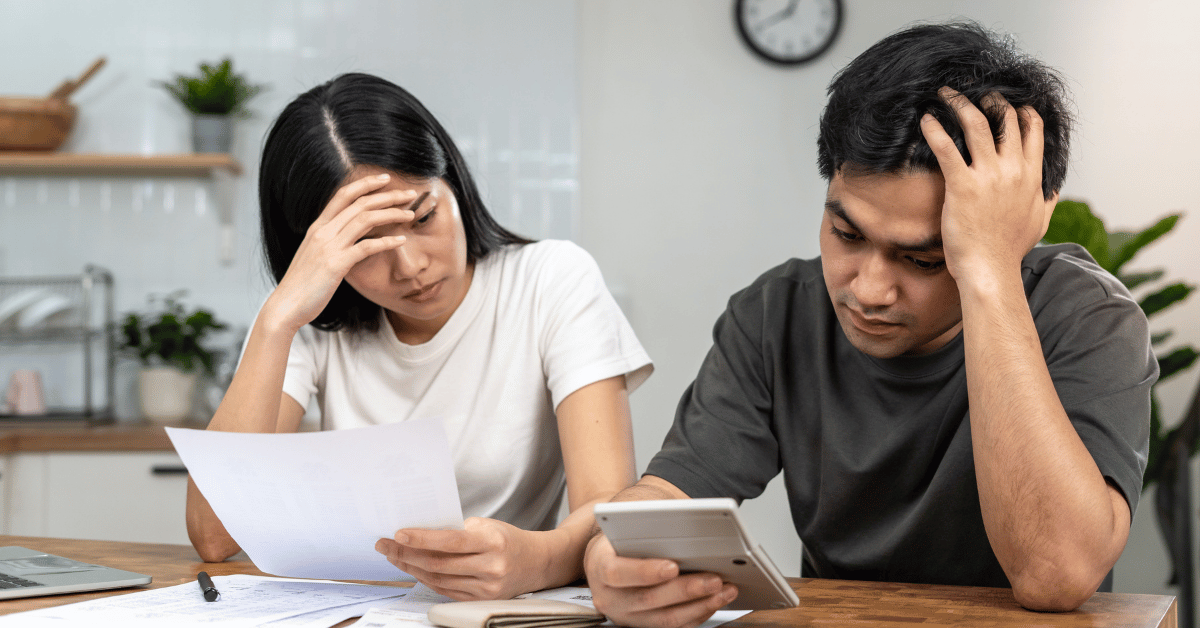 Couple inquiet face à un conseiller bancaire refusant un dossier