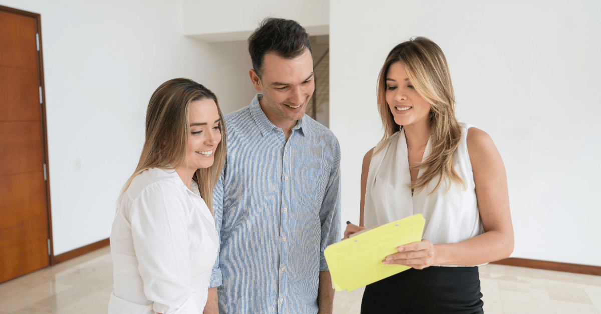 Agent immobilier présentant un logement à un couple