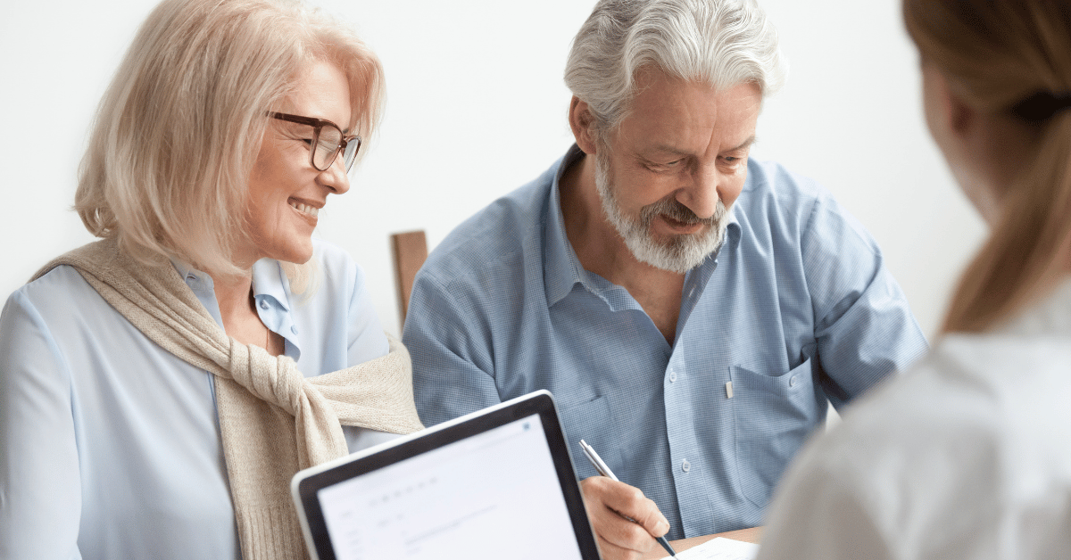 Couple de seniors signant des documents bancaires chez un conseiller