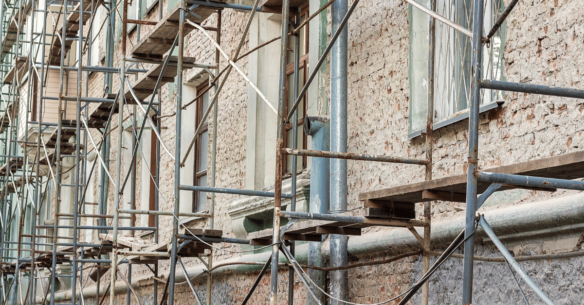 Maison ancienne en rénovation avec ouvriers et échafaudage
