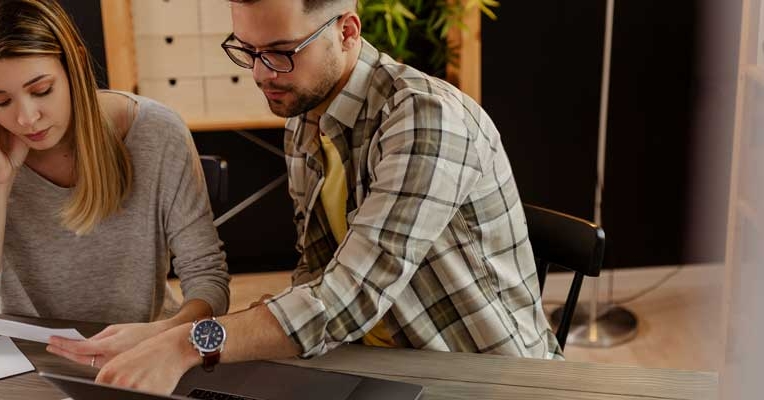 Couple signant des documents bancaires avec calculatrice