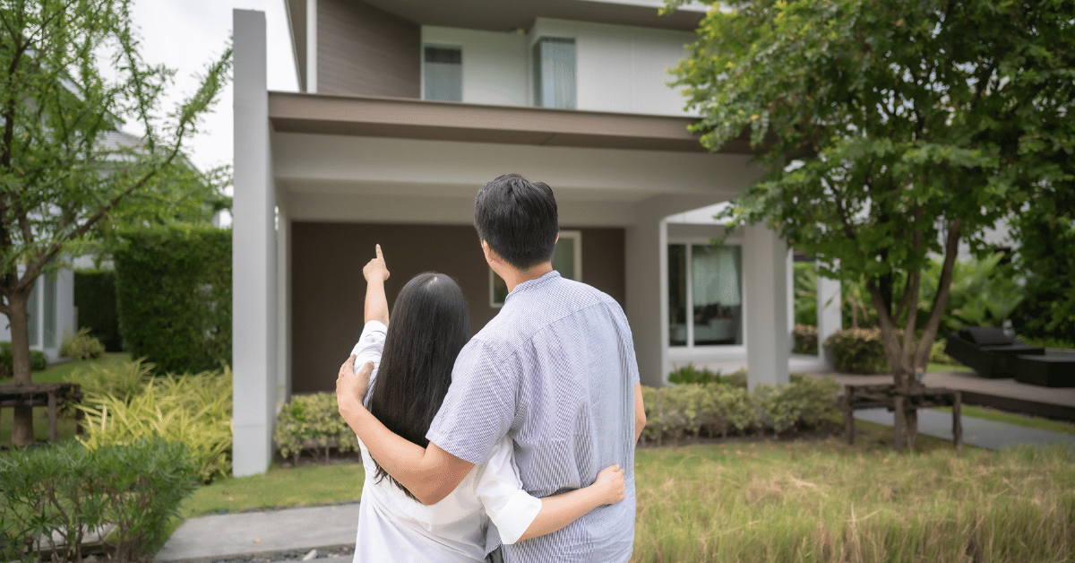 Couple devant une maison avec clés en main