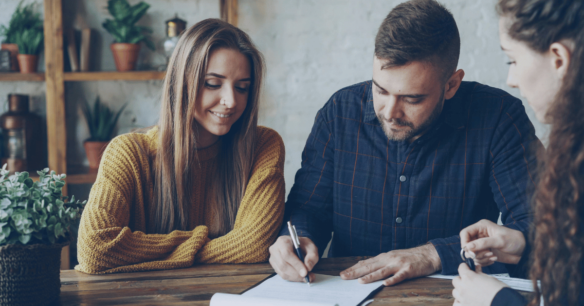 Jeune couple signant un contrat immobilier chez un notaire