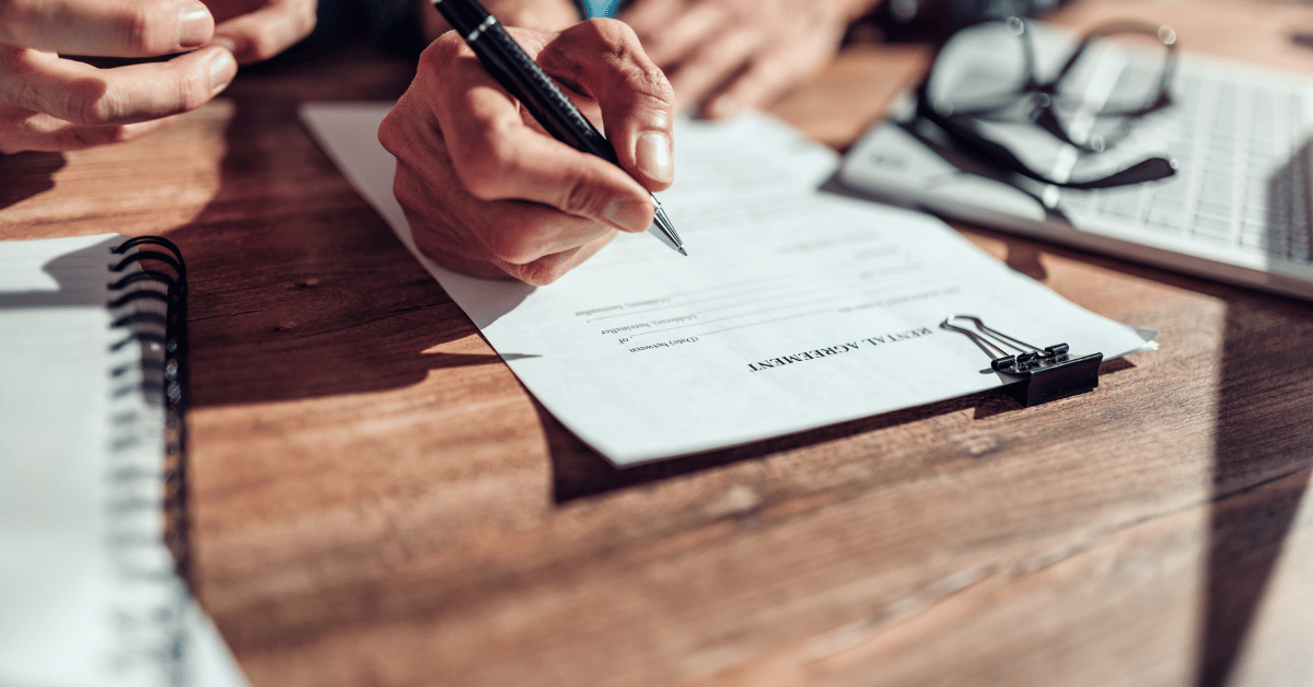 Propriétaire signant un contrat locatif avec documents officiels