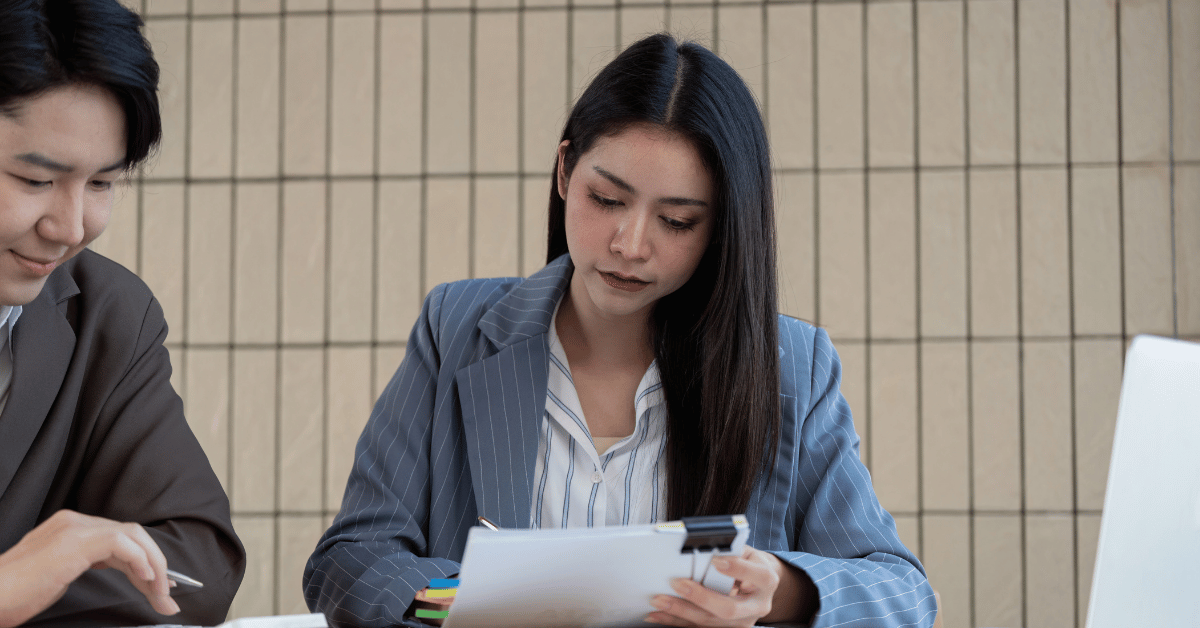 Couple lisant attentivement un contrat d'assurance sur bureau